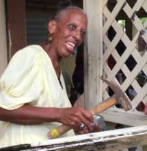A joyful homeowner hammers the last recovery nail