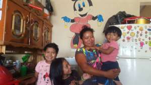 Sherly and her daughters in their new home