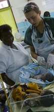 A mother and  her baby guided by a midwive nurse