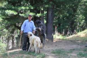 Shefqet playing with his two dogs near his house