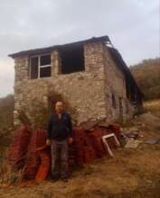 Tafil & his home that was damaged from the bombing