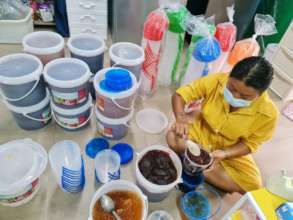 Preparing small pots of jam from donated tubs