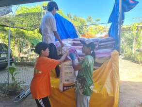 Students helping to unload 6 ton of rice.
