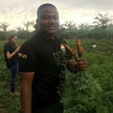 Our founder is holding carrot from the farm