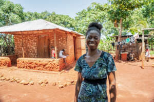 A pgm graduate stands in front of her new home.