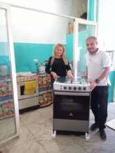 School Principal w/volunteer delivering new stove
