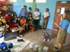Daniela shows children the robot her team built