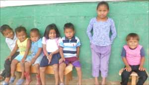 Preschoolers walk through mud to get to class
