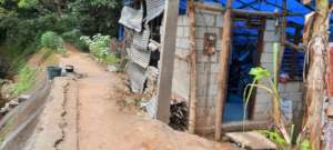 THhe family infront of their house being rebuilt