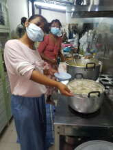 Helping to cook the produce to feed our kids club.