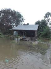 A small hut in the middle of a flooded field.