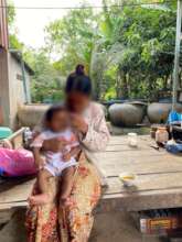 A young mother giving her baby supplementary food