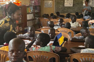 Teacher & students practicing reading in library