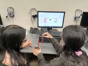 Young women working together on a robot.