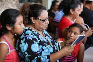 Mother w/daughters reads with new glasses: Mexico