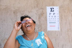 Woman smiles as she receives new glasses