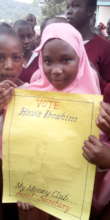 A pupil contestant poses with her campaign poster