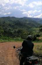 Surveyor on motorbike, en route to visit farmers