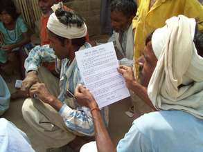 A migrant laborer looking over our education flyer