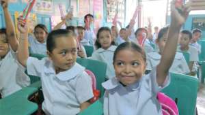 Children proudly displaying a new toothbrush
