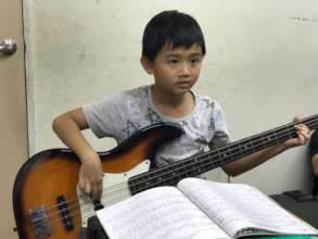 The second grade boy playing bass intently