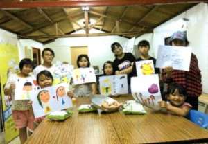 Children posing with their artwork