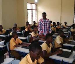 ICT Teacher with his students and their computers