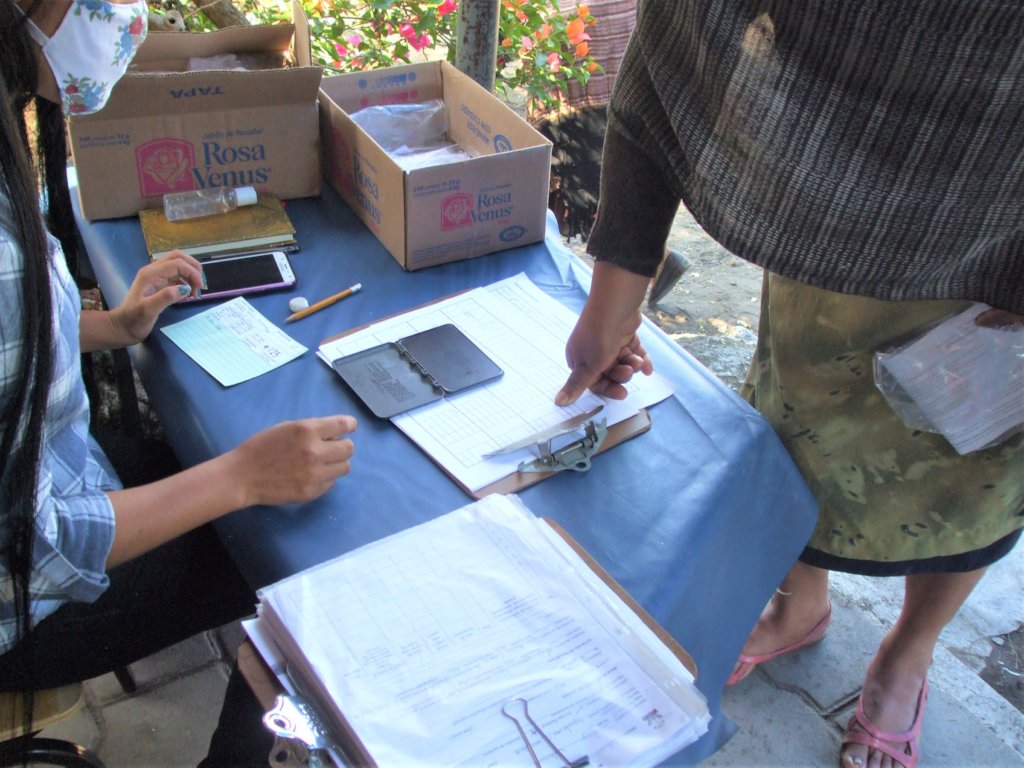 Each woman signs for receipt of food