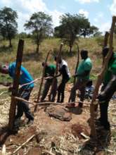 CHWs constructing pit latrine for a poor family.