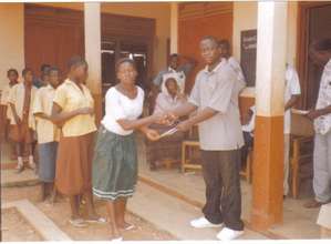 Staff handing scholarship letter to a child