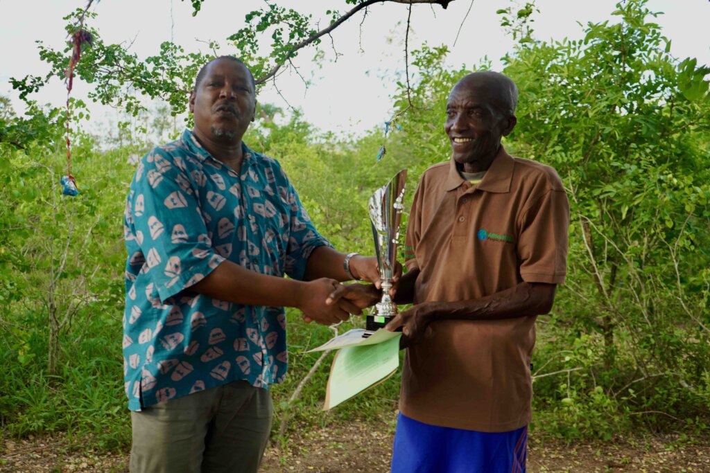 Mzee Mwaringa reciving the Winners Trophy