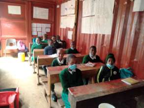 Pupils getting lesson inside container classroom