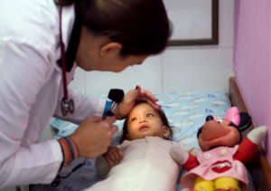 Pediatrician checks eye health - community patient