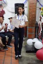 STUDENT WITH HER DIPLOMA AND MEDAL