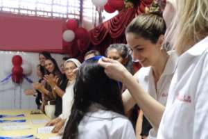 STUDENT RECEIVING HER DIPLOMA AND MEDAL
