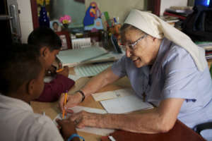 Ma Luisa Casar teaching math to 2 students