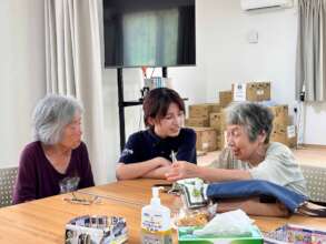 A Peace Winds volunteer talks with survivors