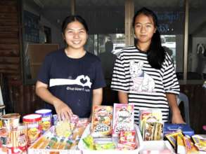 Fern (smiling) and a friend selling snacks