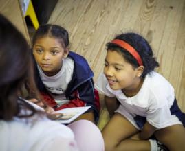 Youth reading a story to children