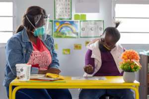 A volunteer and a child play a game