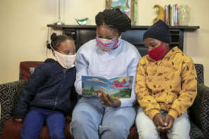 Adult reading with two children