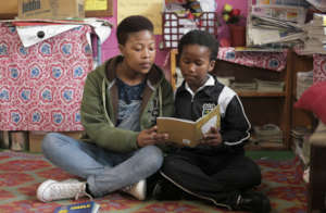 Youth volunteer reading to a child
