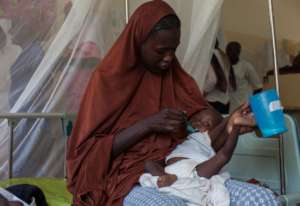 A Nigerian mother gives her child fortified food.