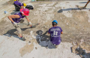 Volunteers Prepping a Damaged Roof for Sealant