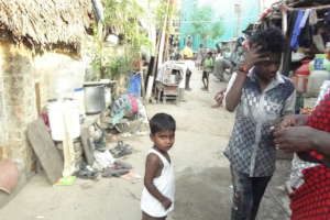 A child and others in an alleyway lined with homes