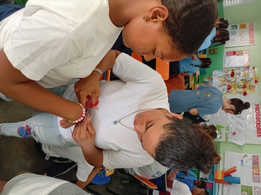 Fiordelis helping students make bracelets