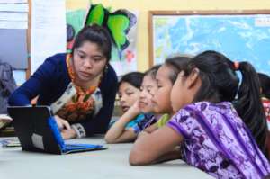 Librarian Ms. Clara helps students use the program