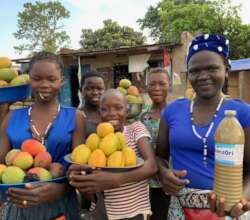 Youth selling shea butter & fruit on road to camp