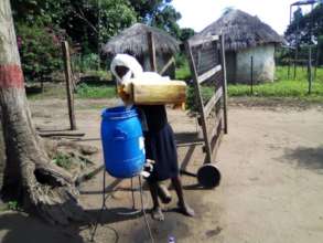 Filling the water stand for handwashing