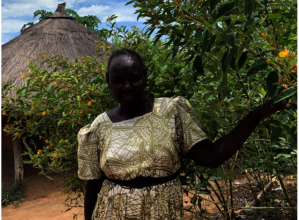 Refugee mother with pigeon peas, papaya from ICRAF